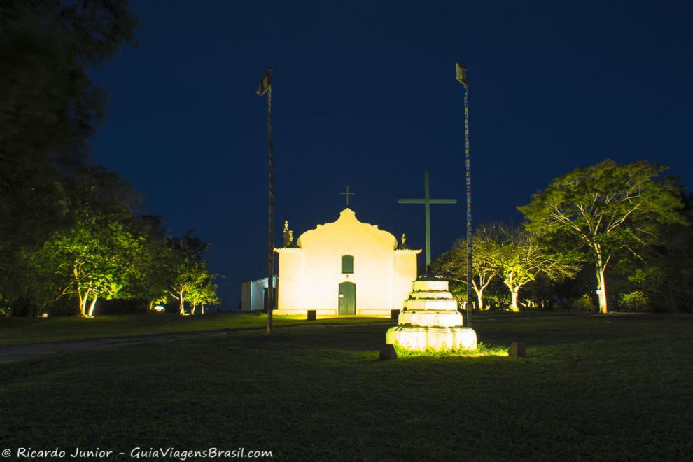 Imagem da praça a noite com a igreja iluminada em Quadrado.